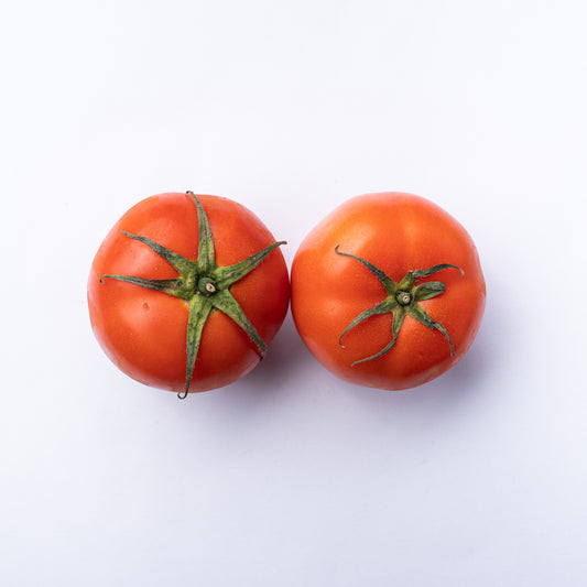 Two red tomatoes with green tops.
