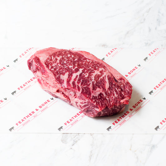 A Wagyu Sirloin MBS7 beef steak on a marble slab.