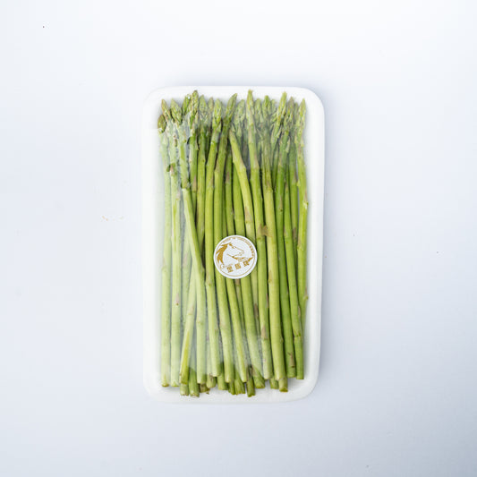 A polystyrene tray of slender asparagus spears with plastic wrap.