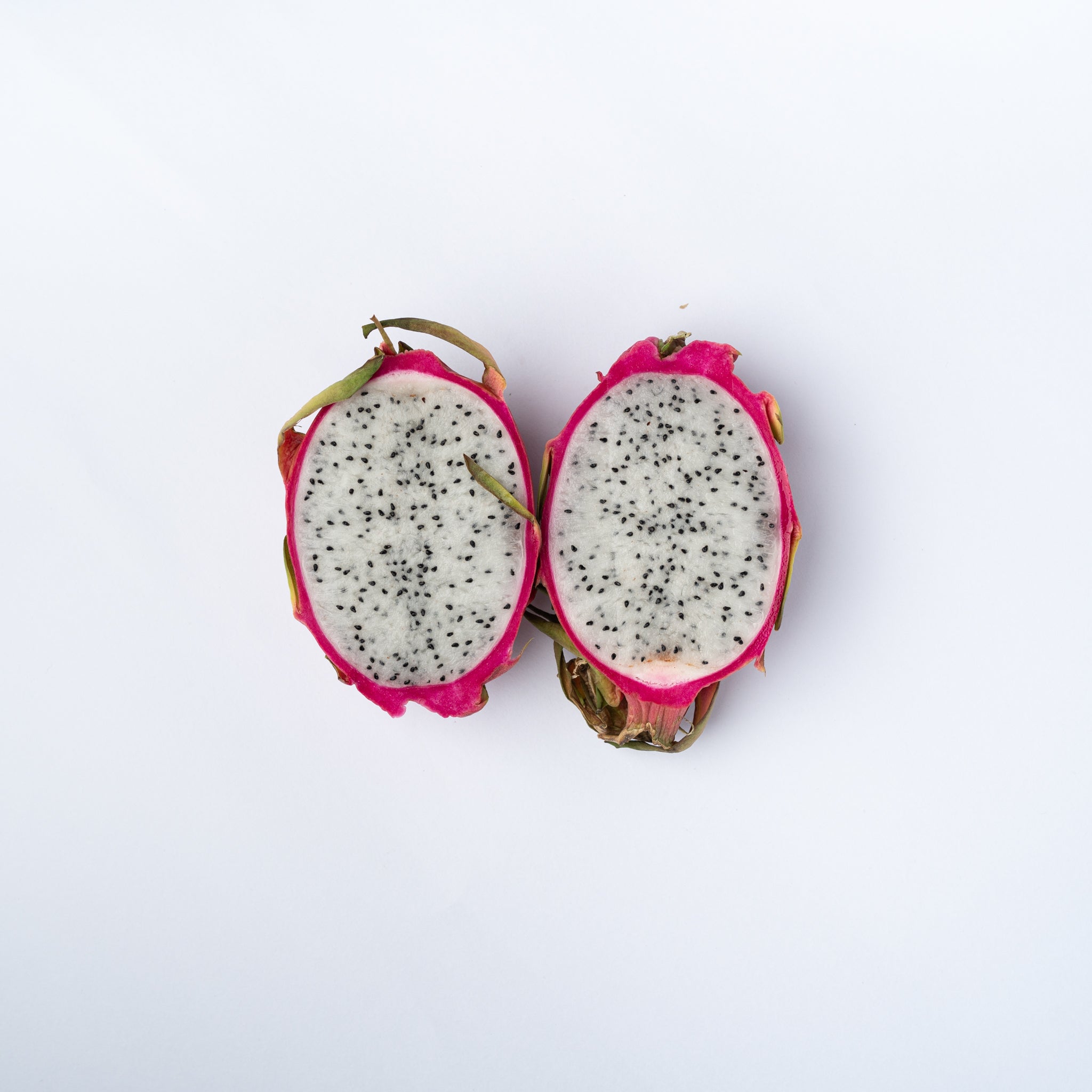 A white fleshed dragonfruit cut in two halves.