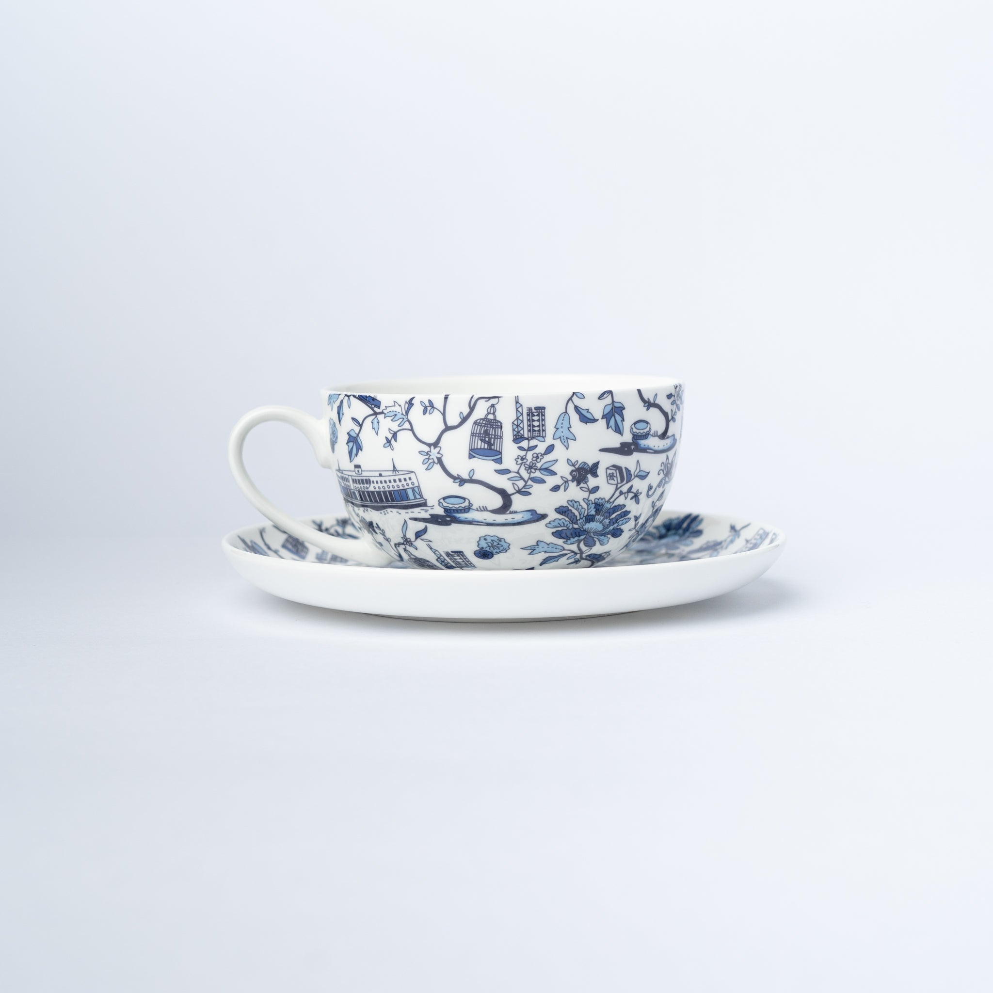 A cup and saucer with a blue and white design of iconic Hong Kong imagery.