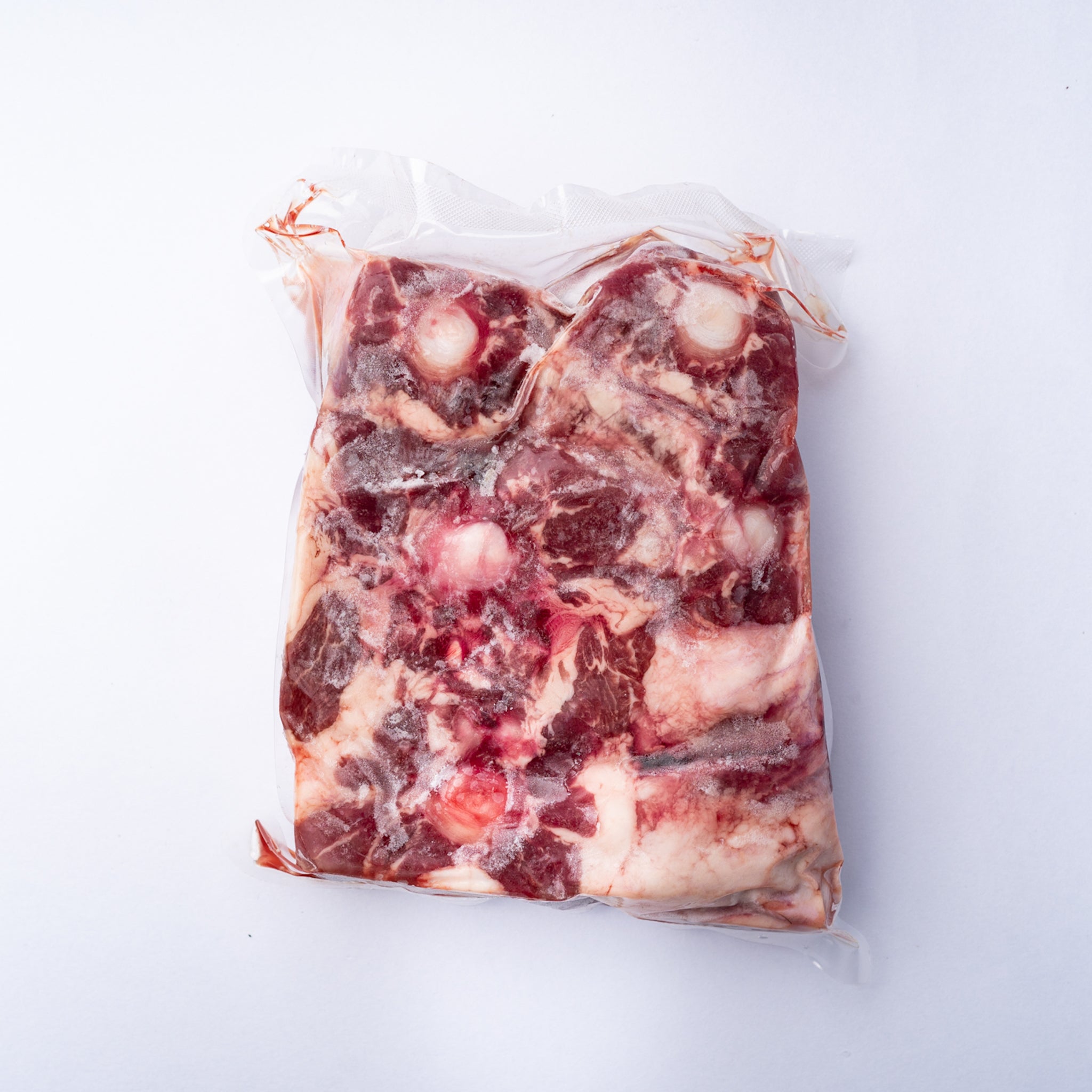 Grain Fed Angus Ox Tail pieces in a vacuum bag.