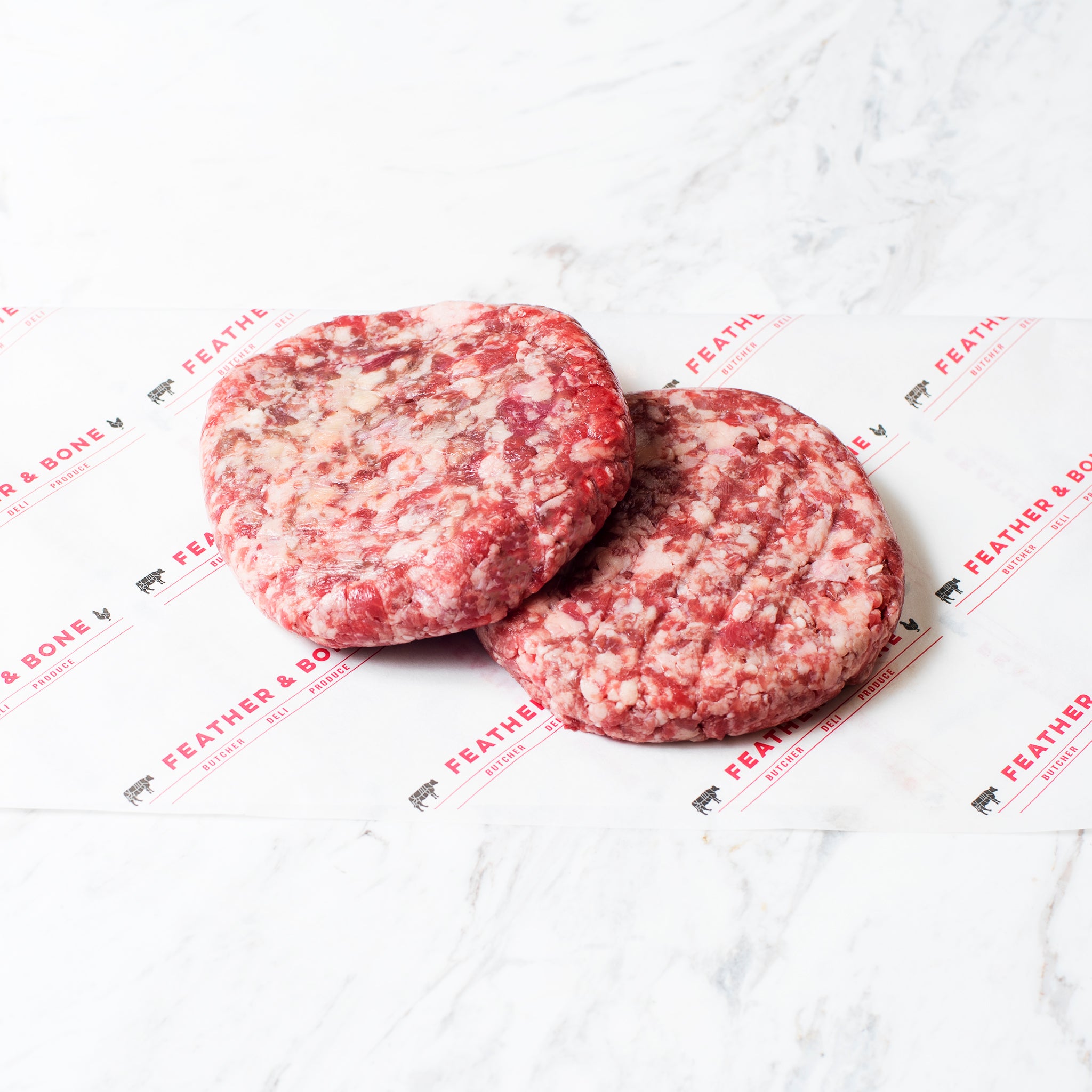 Two 200g Wagyu Beef Patties on Feather & Bone branded butchers paper.