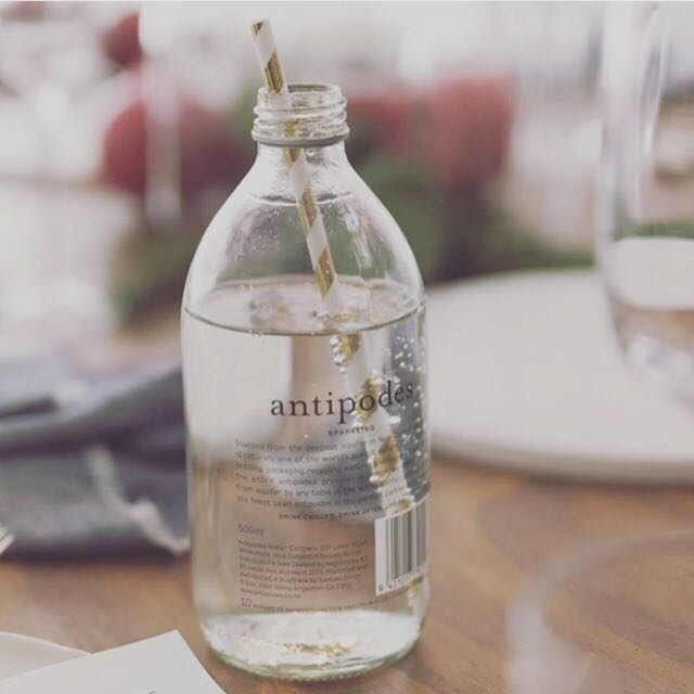 a 1l glass bottle of antipodes sparkling water in a trendy café setting