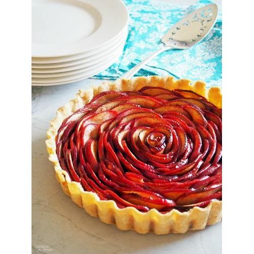 A tarte shell with ornate sliced red apple.