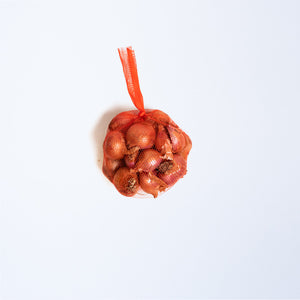 A red string bag of shallots.